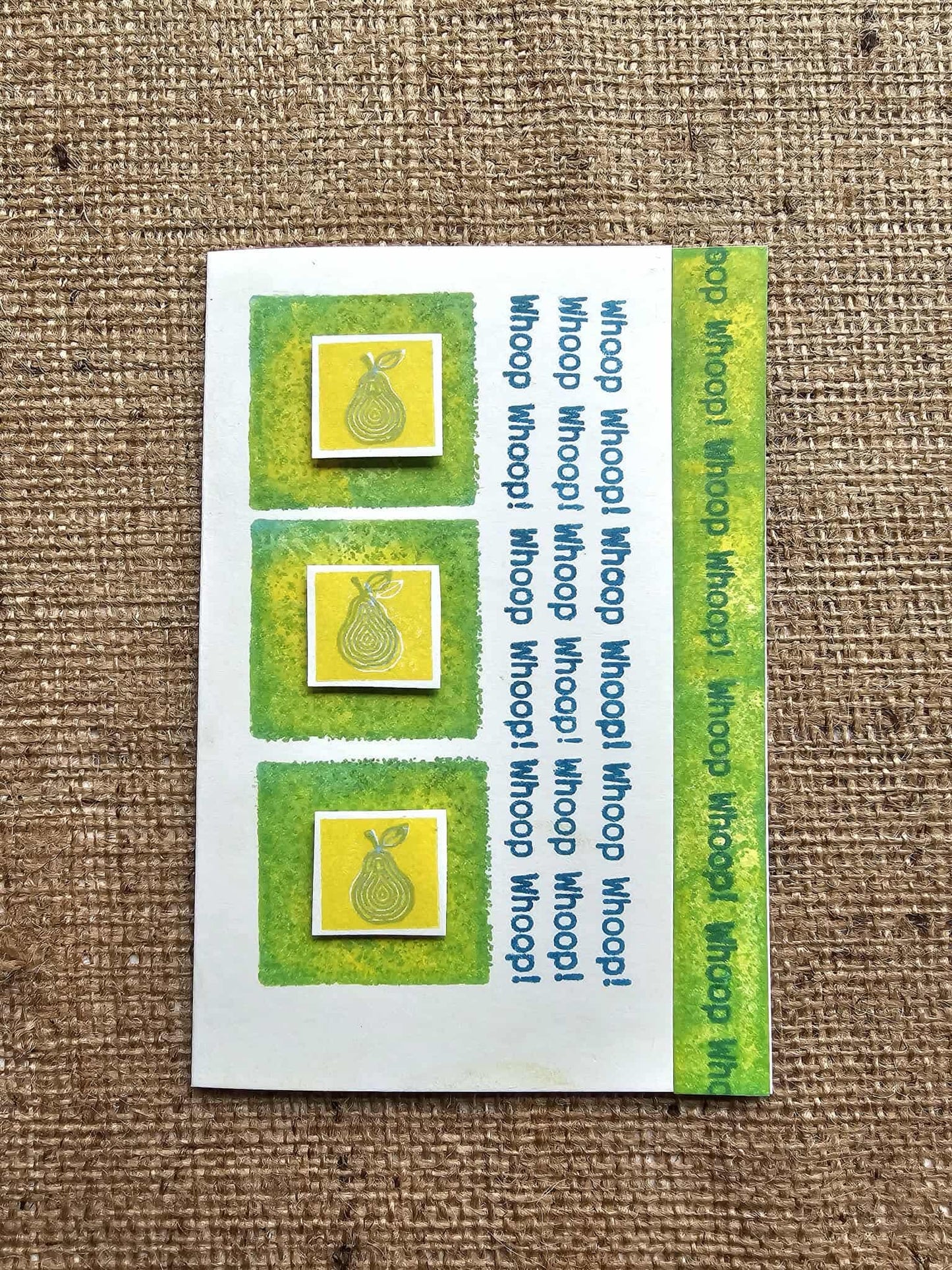 Set of three pear-shaped stamps on a white card with green border, displayed on a textured brown background.