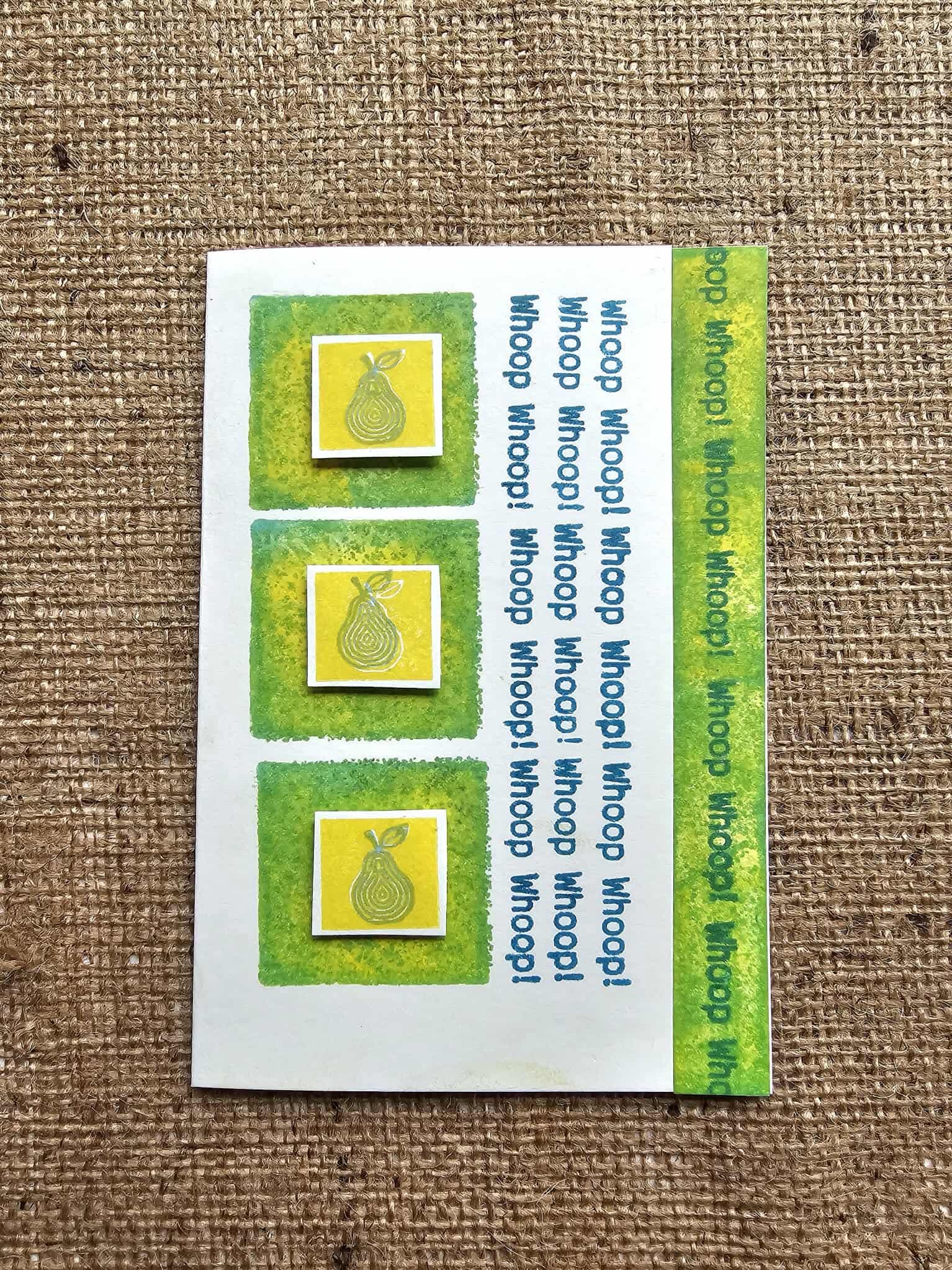 Set of three pear-shaped stamps on a white card with green border, displayed on a textured brown background.