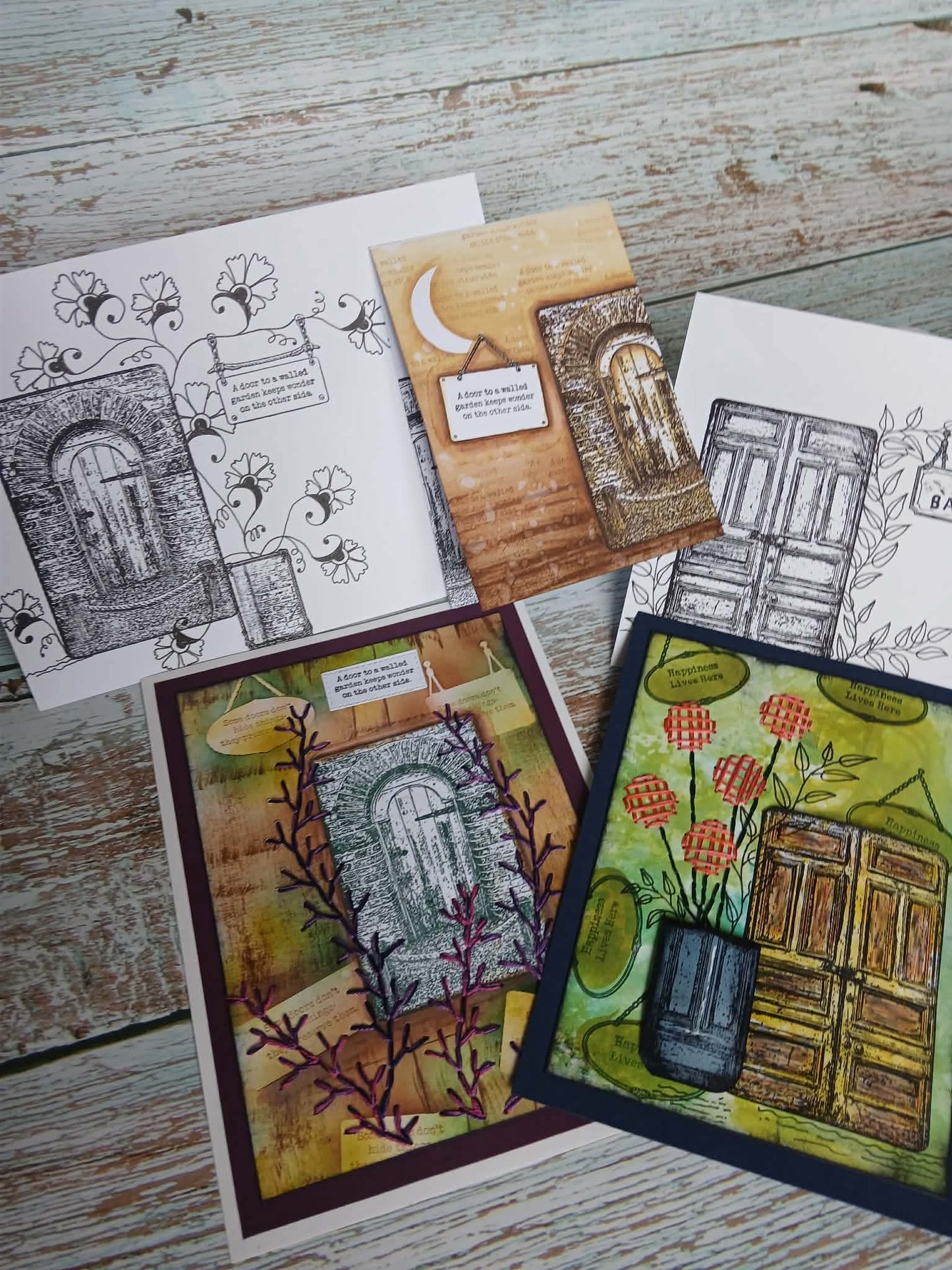 Collection of artistic greeting cards on a wooden surface