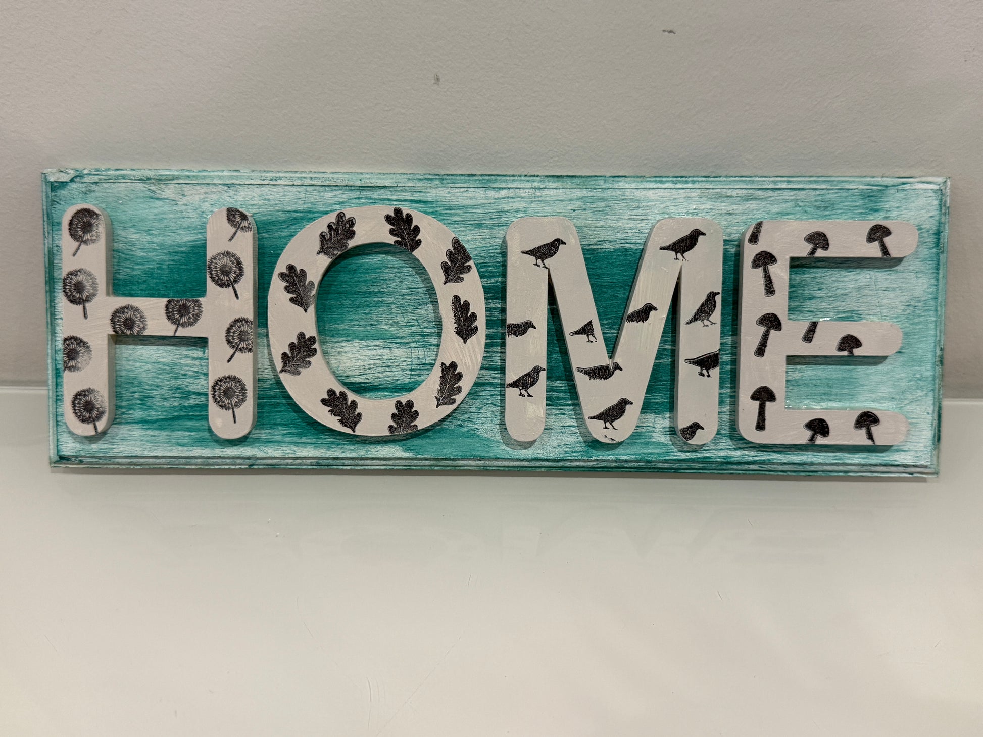 Decorative sign with 'HOME' letters on a wooden background