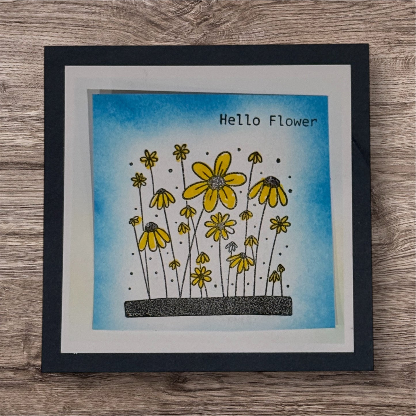 Framed artwork with yellow flowers and 'Hello Flower' text on a blue background