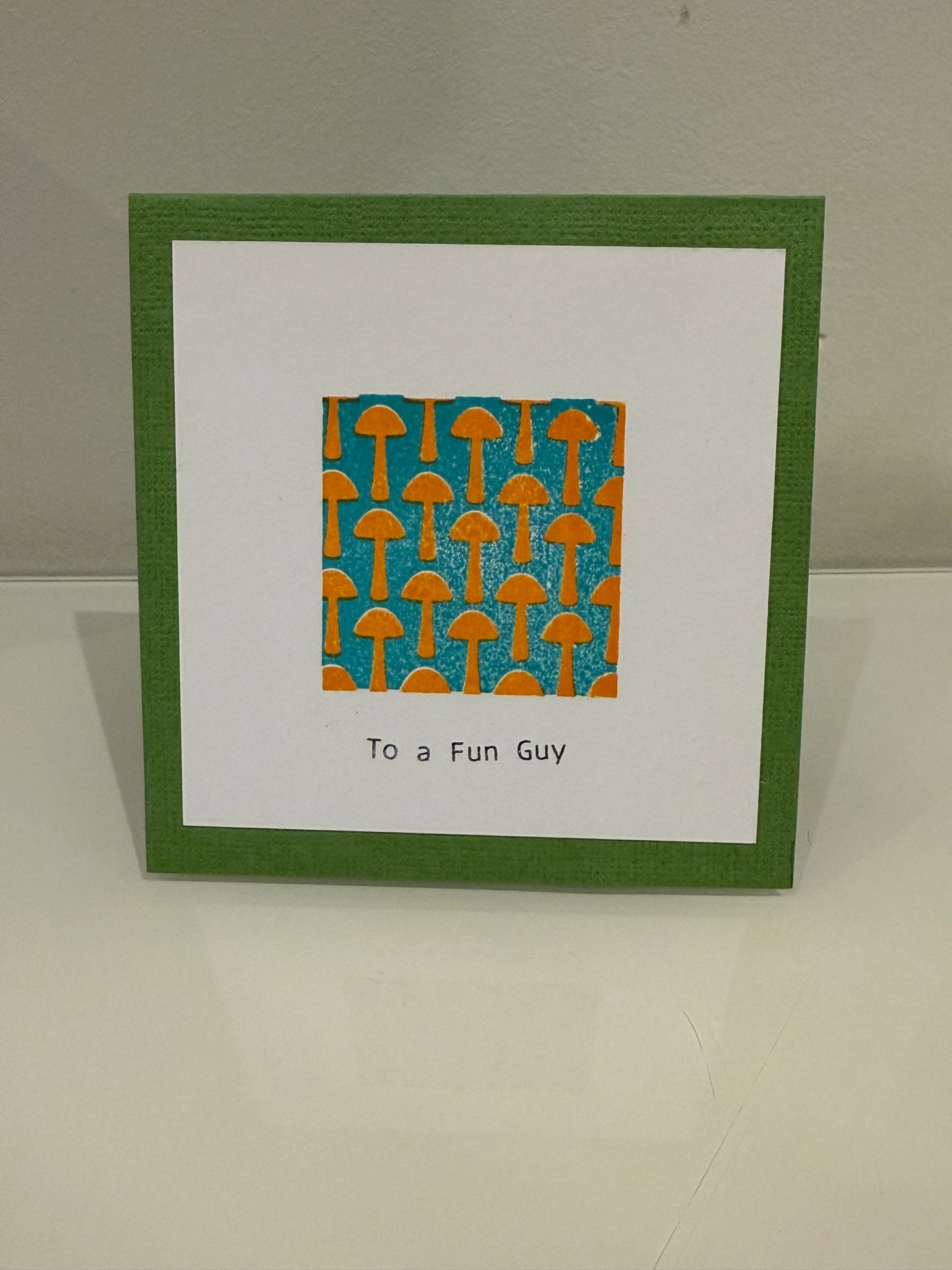 Greeting card with green border and orange and blue pattern on a white background