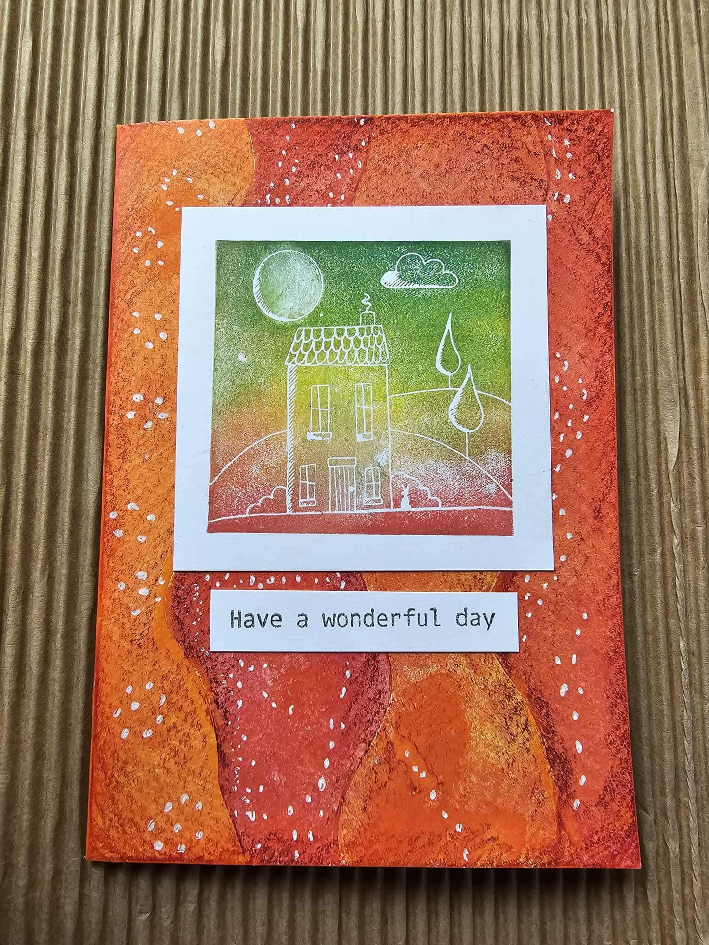 Greeting card with a house illustration and 'Have a wonderful day' text on an orange background.