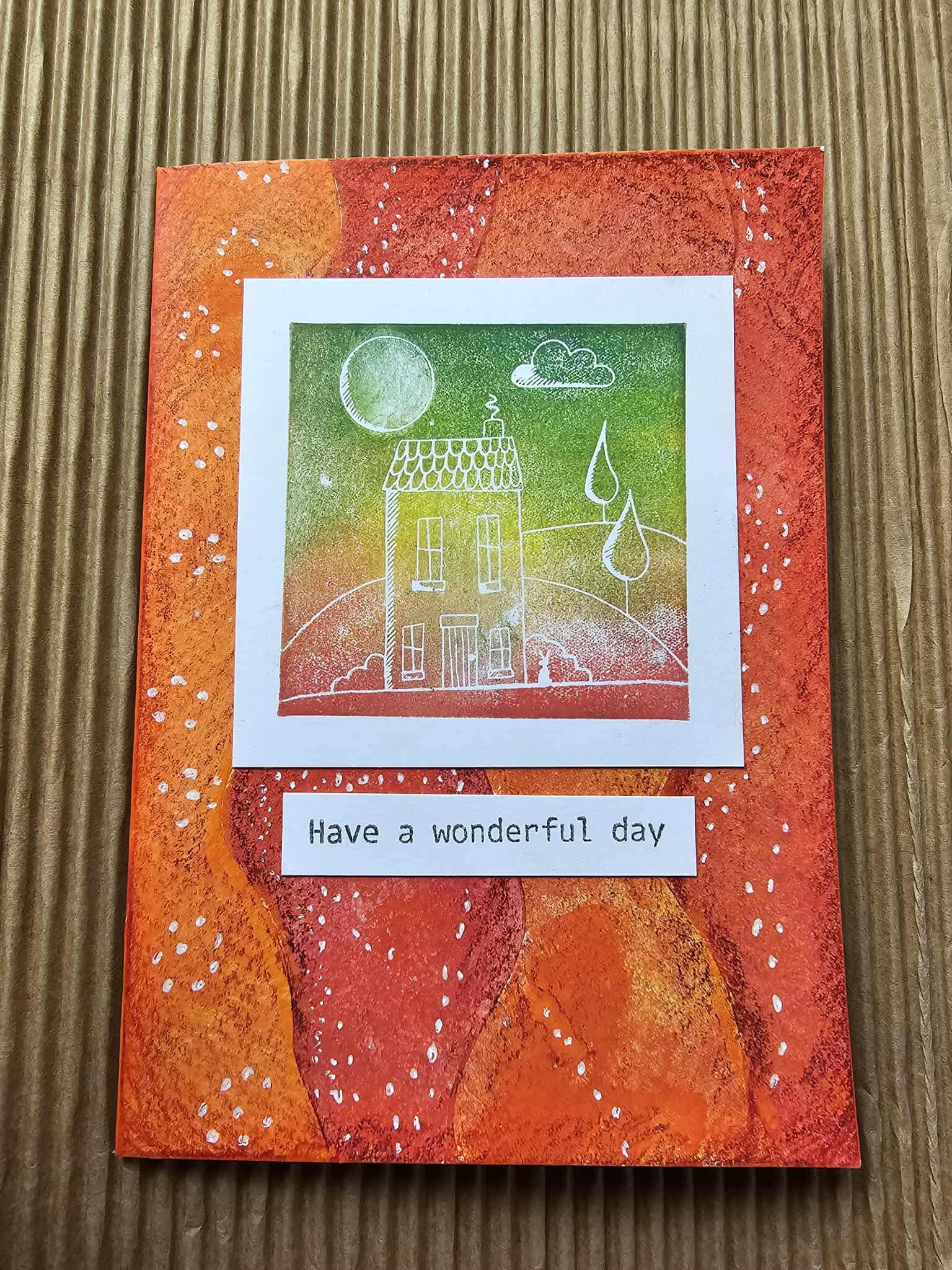 Greeting card with a house illustration and 'Have a wonderful day' text on an orange background.