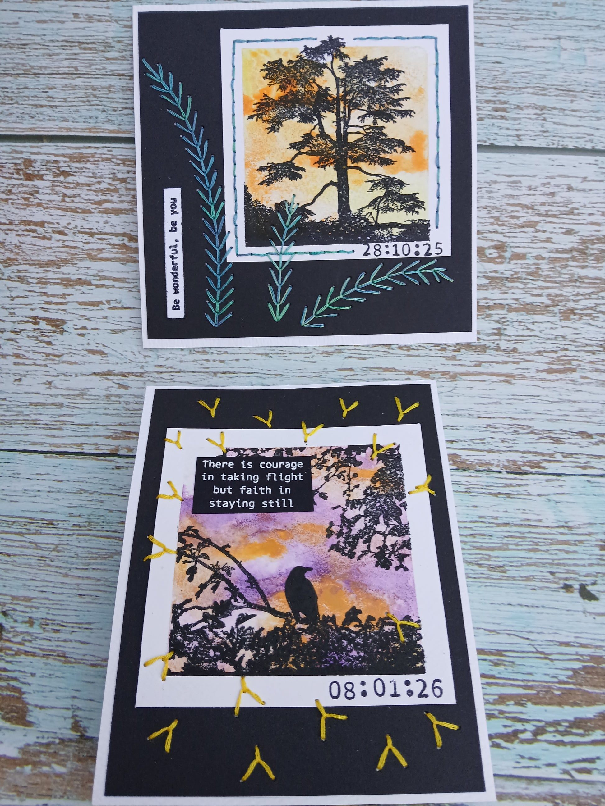 Two greeting cards with nature-themed designs on a wooden surface