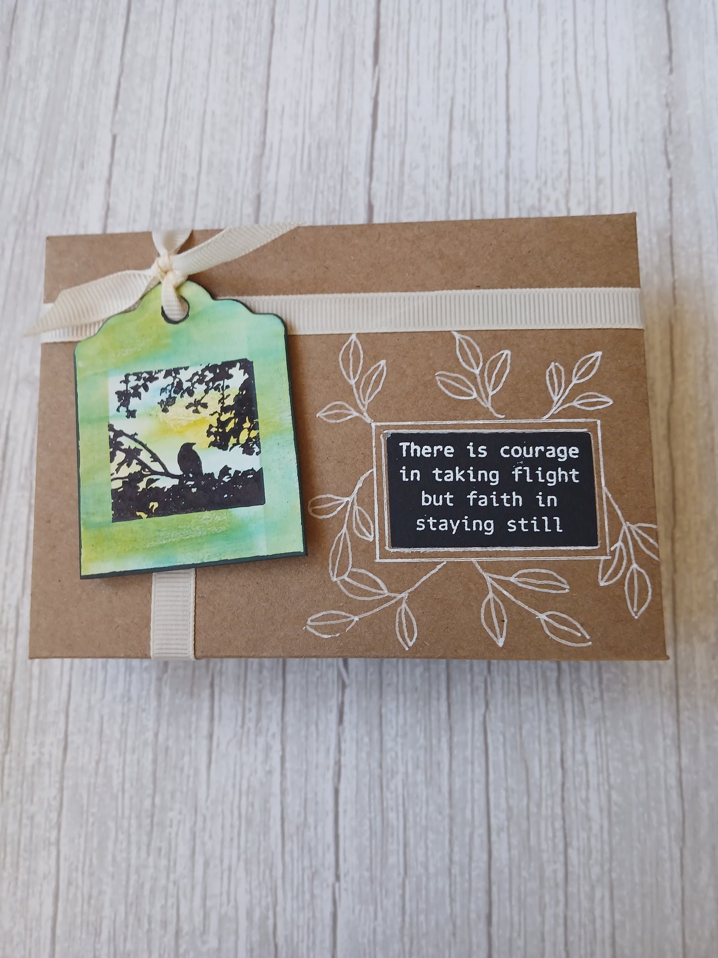 Brown paper card with a tag and text on a wooden surface