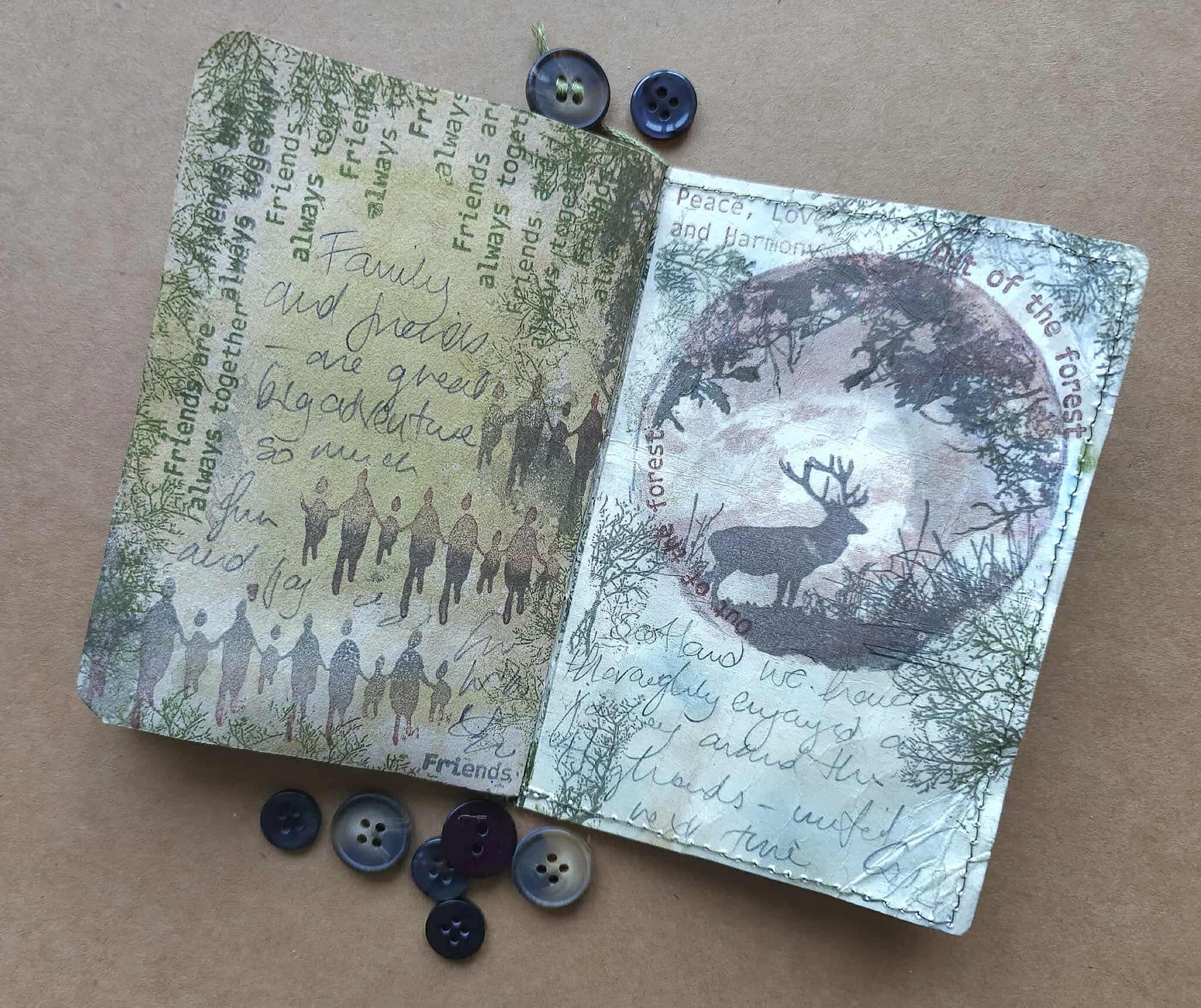 Two small books with nature-themed covers on a brown surface with buttons.