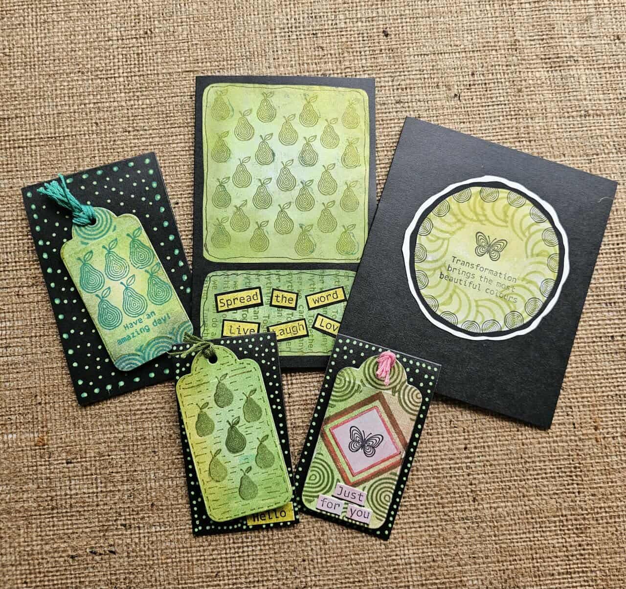 Set of greeting cards and tags with green and black patterns on a textured brown background