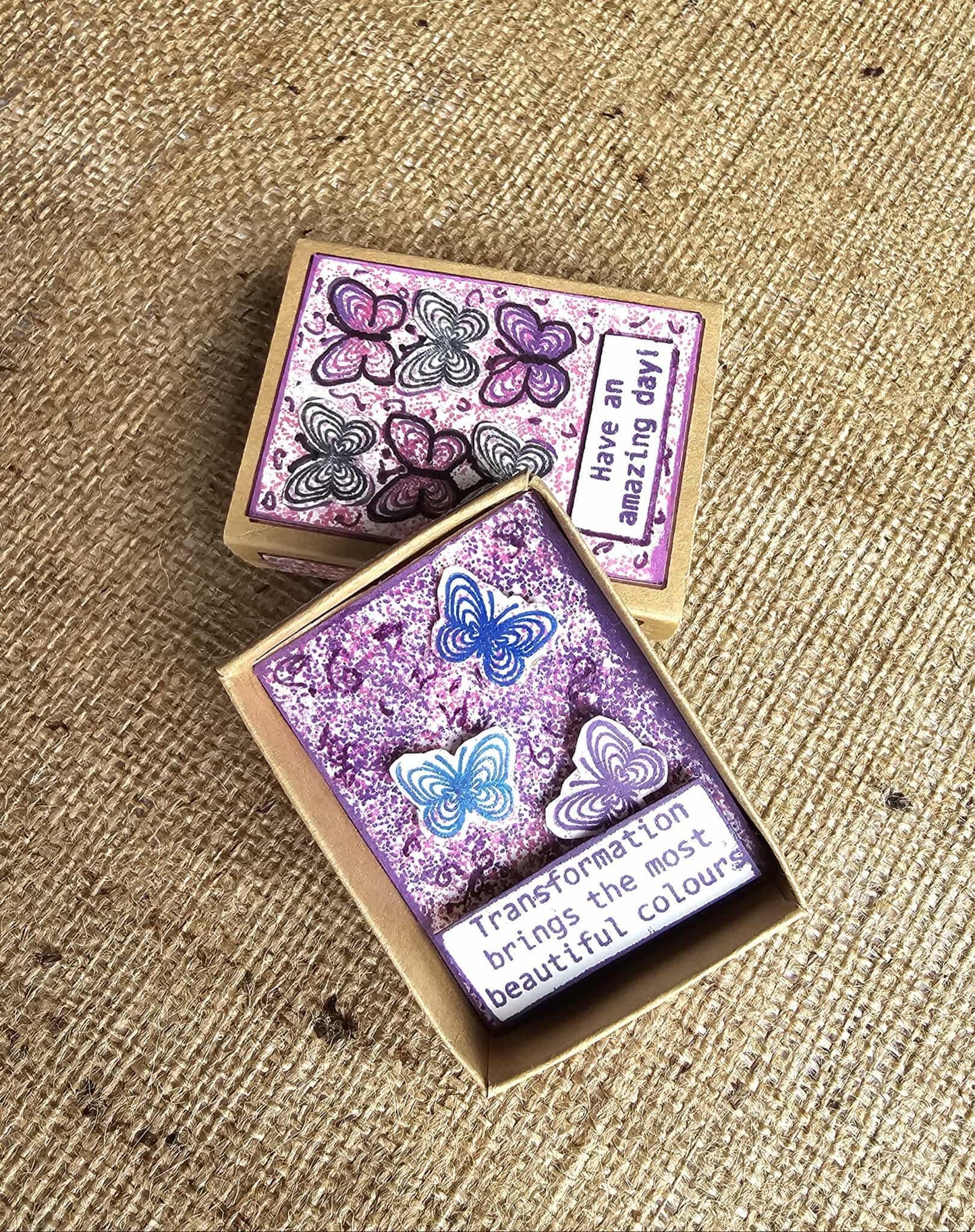 Two rubber stamps with butterfly designs and text on a textured surface