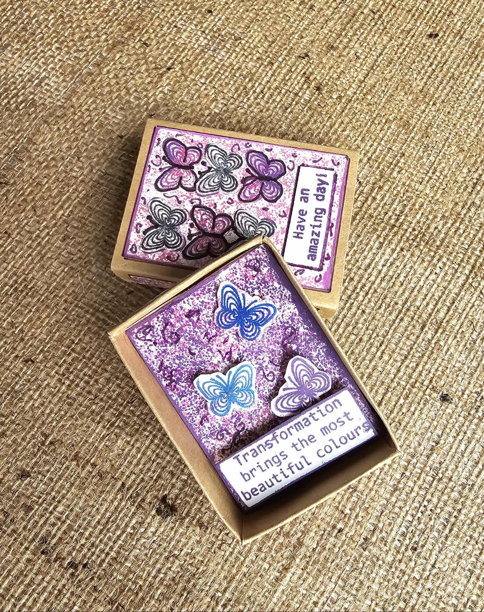Two rubber stamps with butterfly designs and text on a textured surface