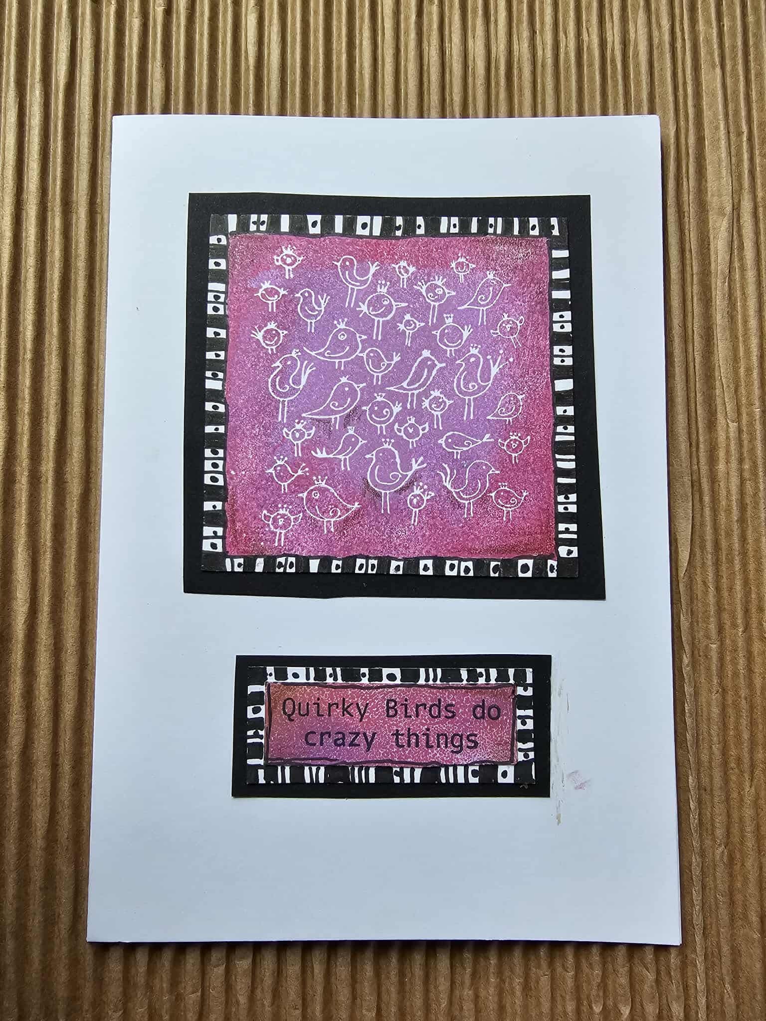 Greeting card with pink and black design on a textured surface