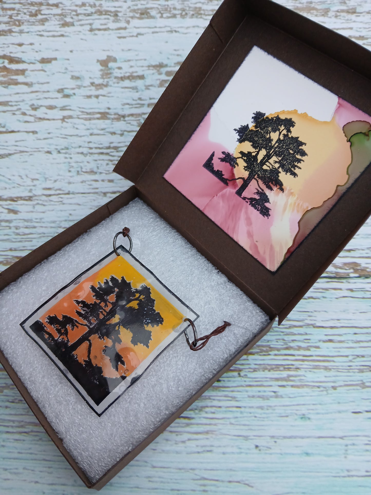 Decorative item with tree design in a box on a wooden surface