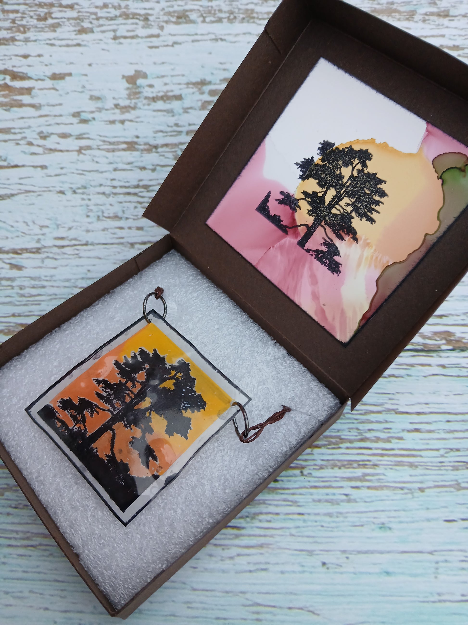 Decorative item with tree design in a box on a wooden surface