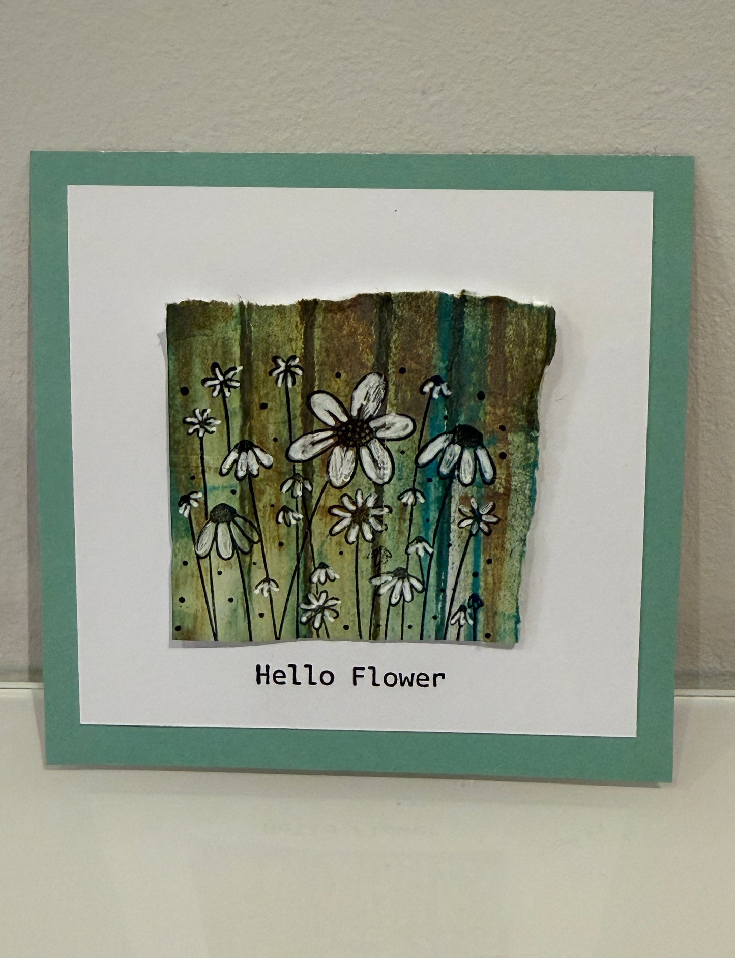 Card with floral design and 'Hello Flower' text on a textured surface