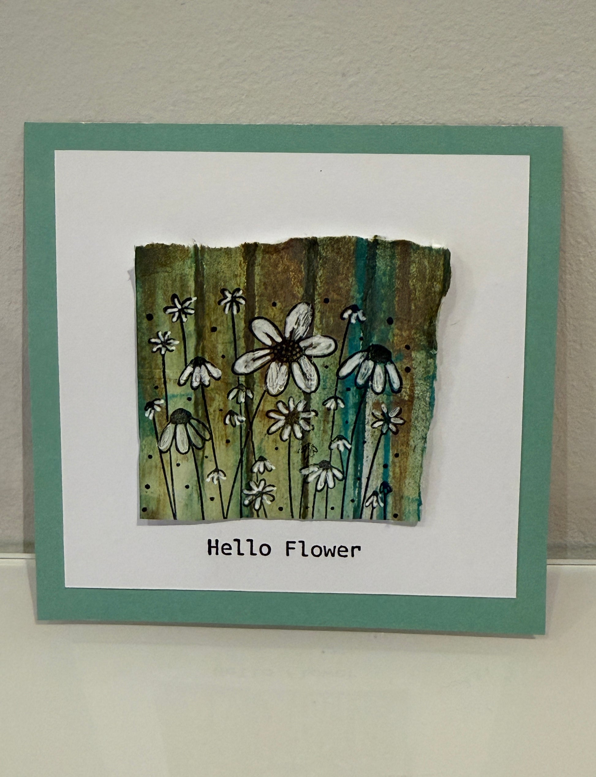 Card with floral design and 'Hello Flower' text on a textured surface
