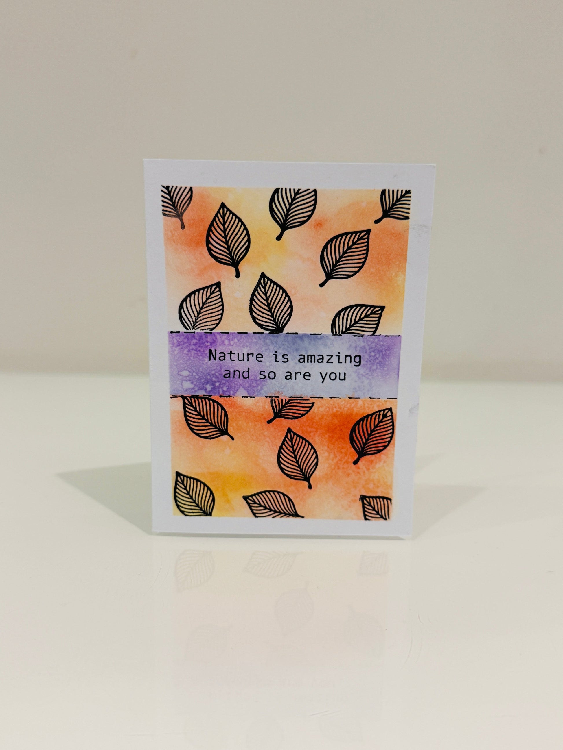 Greeting card with leaf pattern and 'Nature is amazing and so are you' text on a gradient background