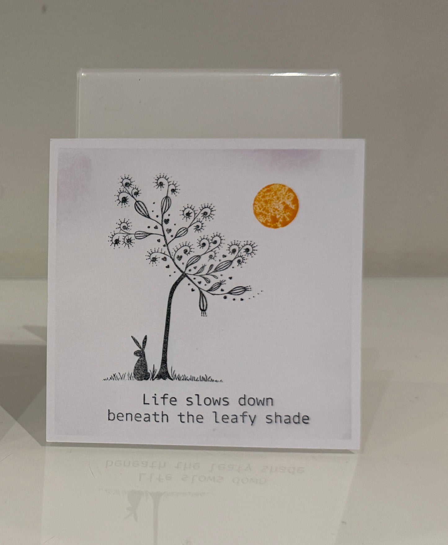 Illustration of a hare under a tree with a moon and text