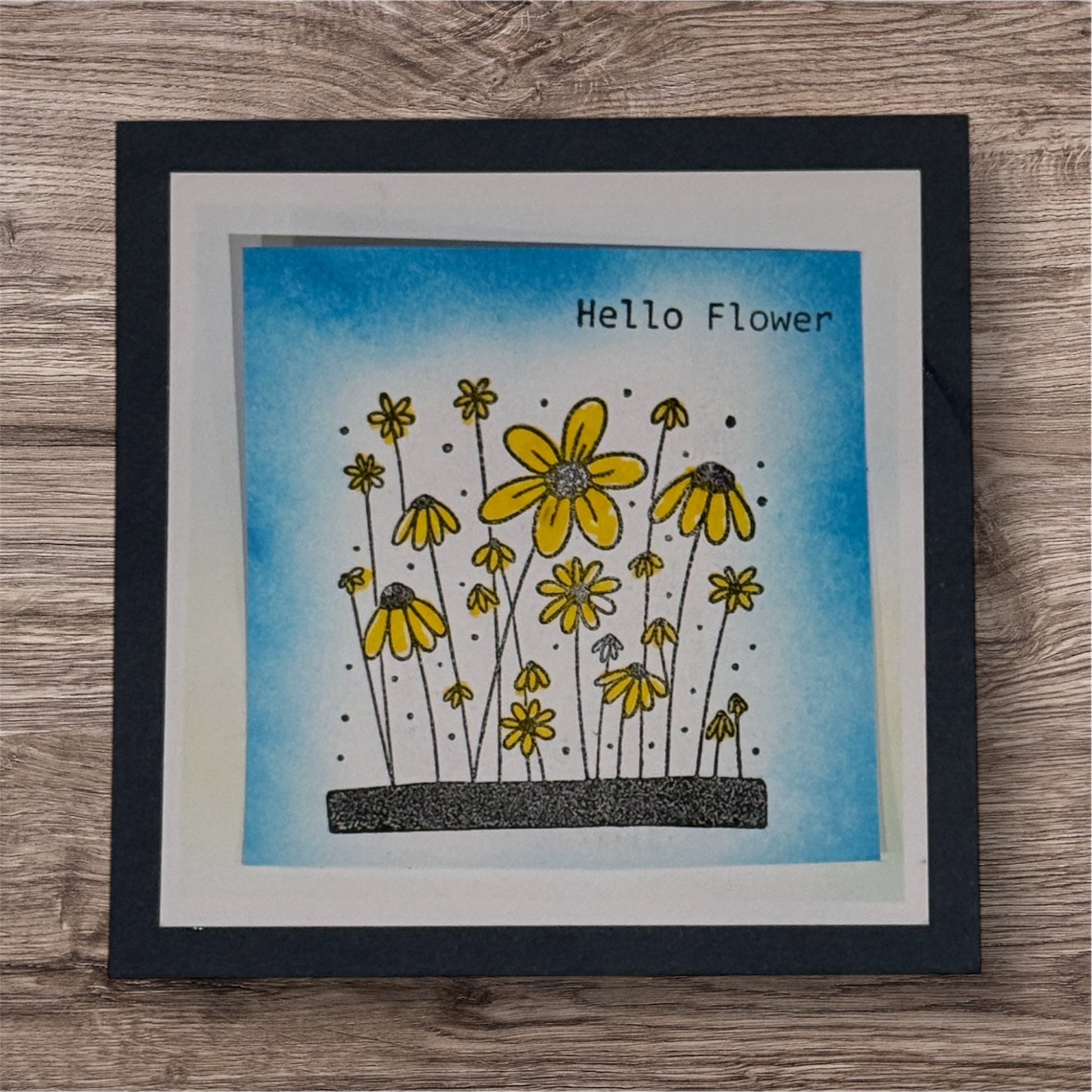 Framed artwork with yellow flowers and 'Hello Flower' text on a blue background