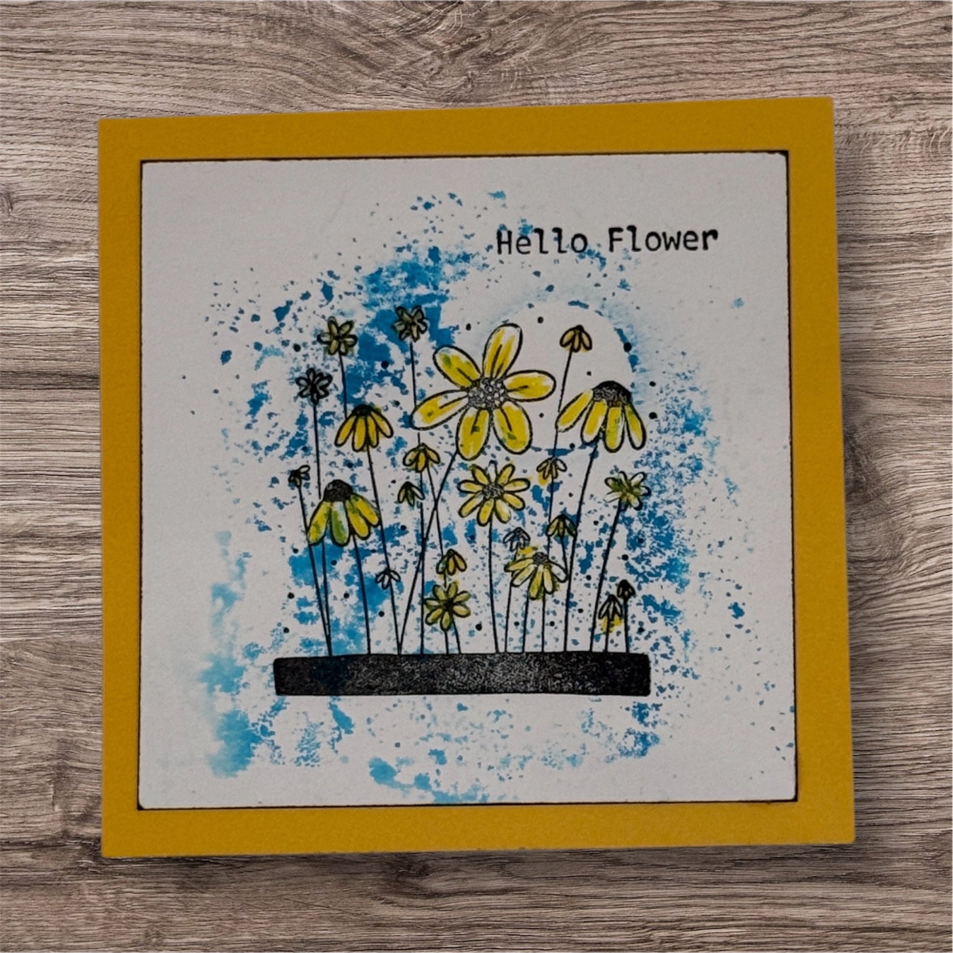 Card with yellow flowers and 'Hello Flower' text on a wooden surface