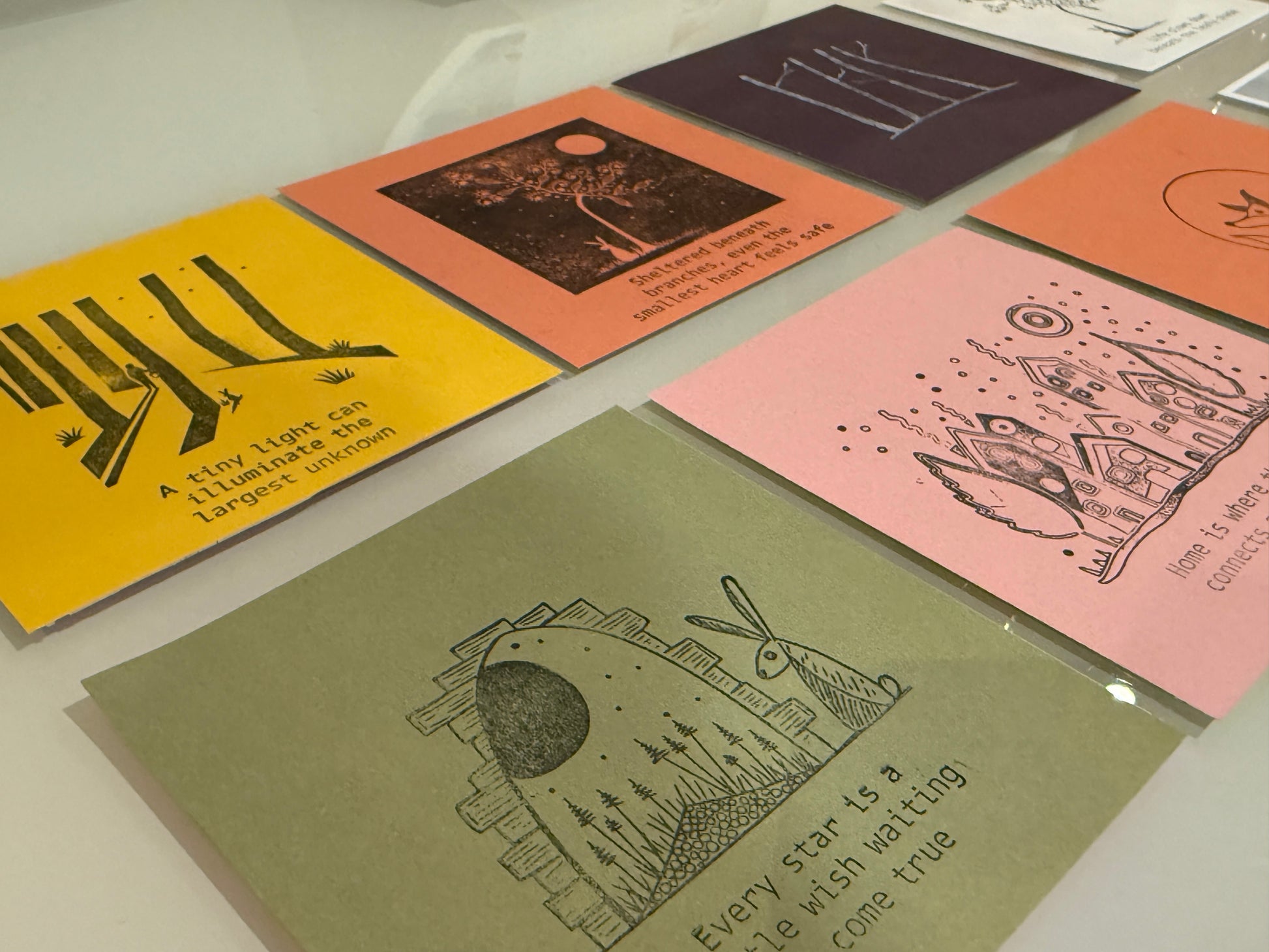 Collection of illustrated cards on a white surface