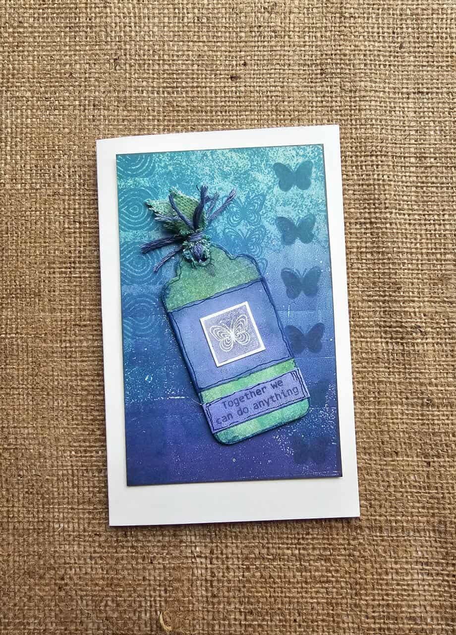 Greeting card with blue and green design on a textured brown background