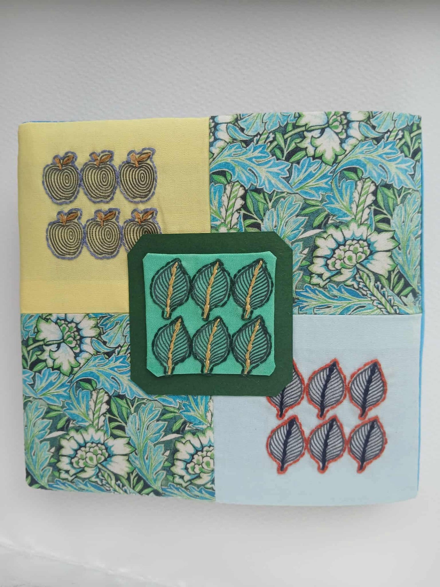 Patchwork fabric square with various patterns on a white background