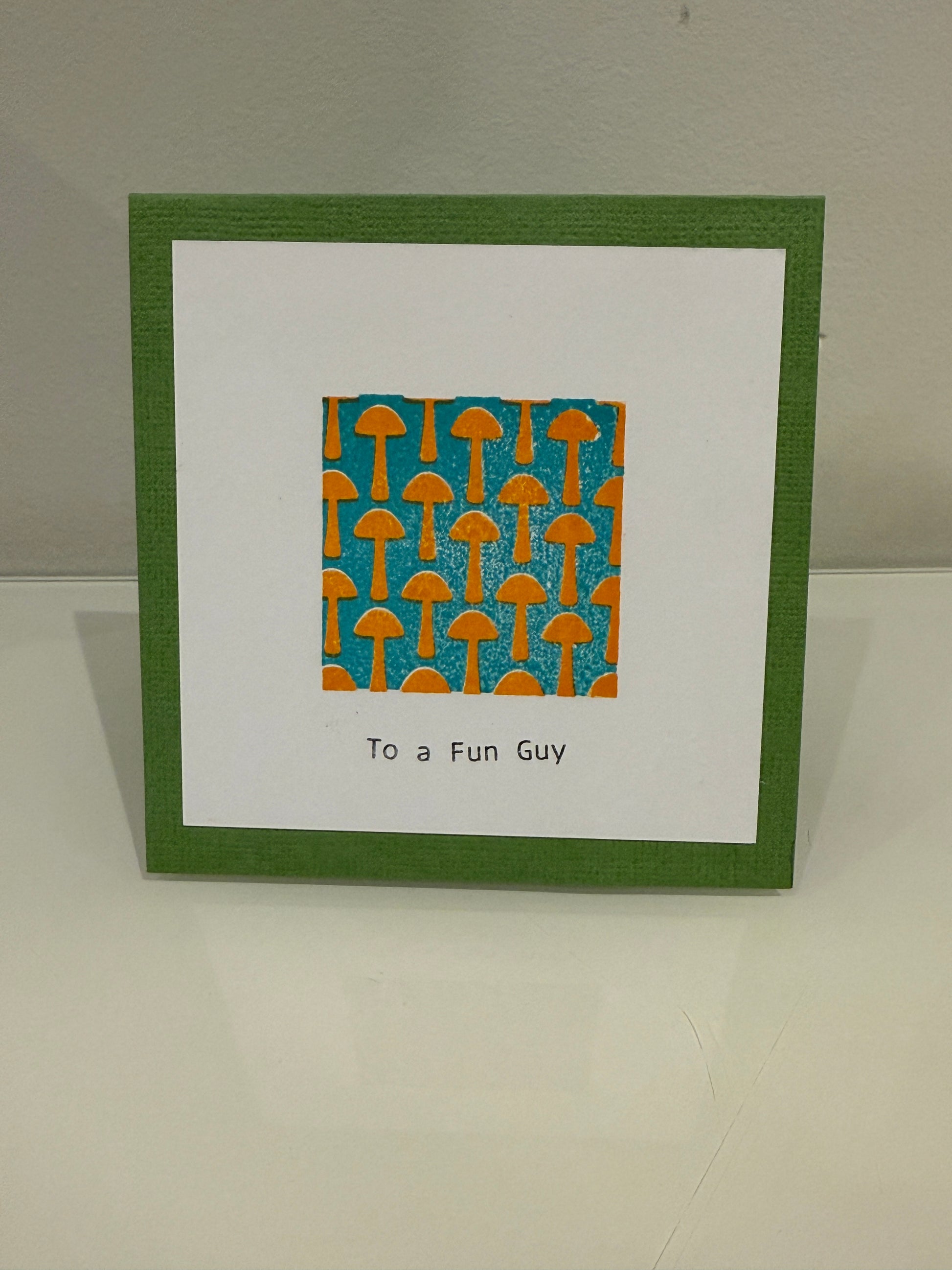 Greeting card with green border and orange and blue pattern on a white background